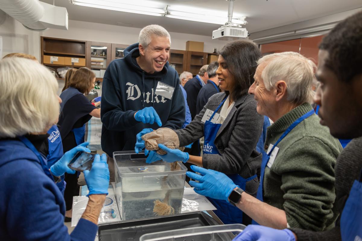 Dr. Hariri showing model brains to alumni