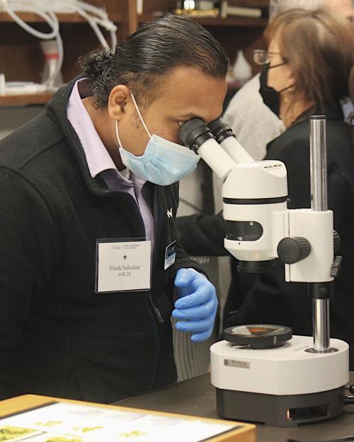 Duke alum uses lab microscope to get closer view of brain tissue. 